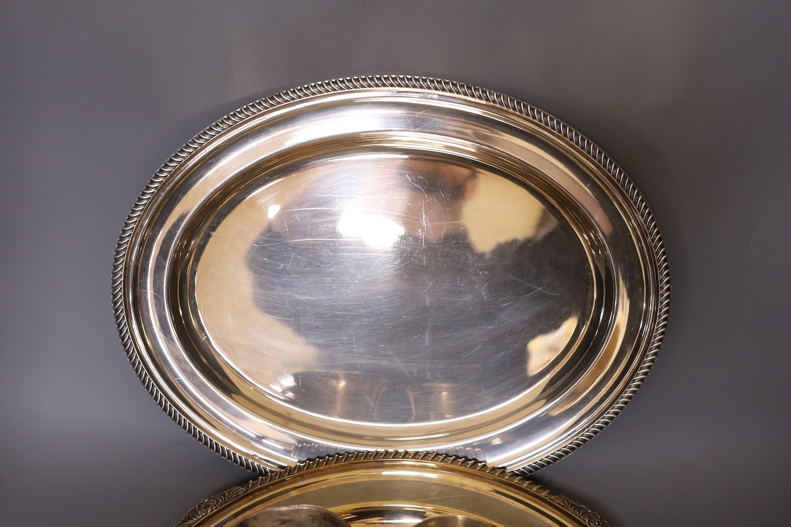 A silver plated tray, an oval plated serving dish and two silver plated mugs. Largest 41cm